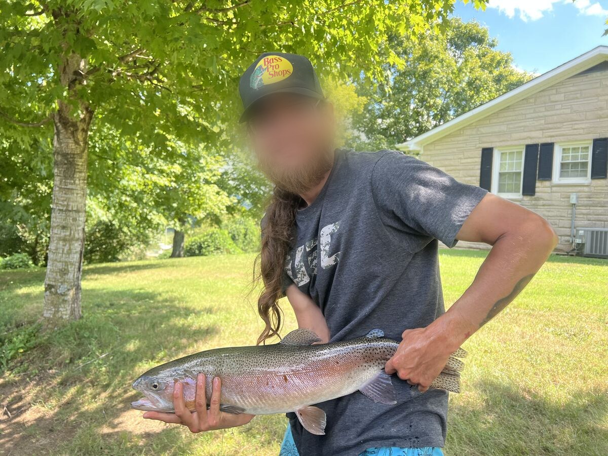 Happy angler holding a rainbow trout caught at Dale Hollow
